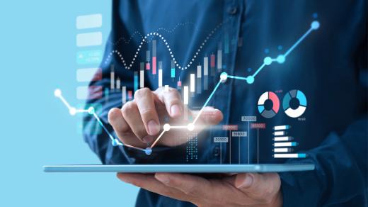 a hand working on a tablet with a graphic overlay of a business data chart