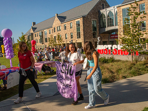 people walking and smiling on a college campus