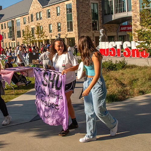people walking and smiling on a college campus