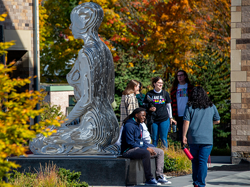 Students gathered around a statue on SHU campus