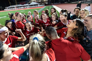 Girls huddle together on field