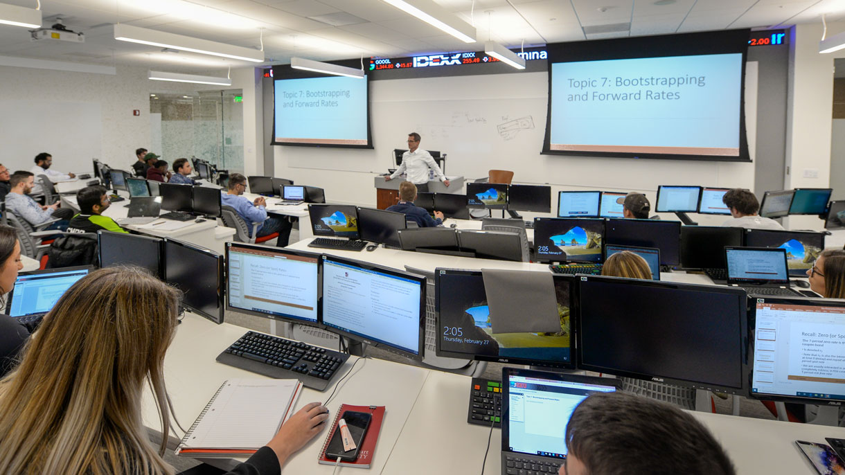 Students listening to teacher in finance lab