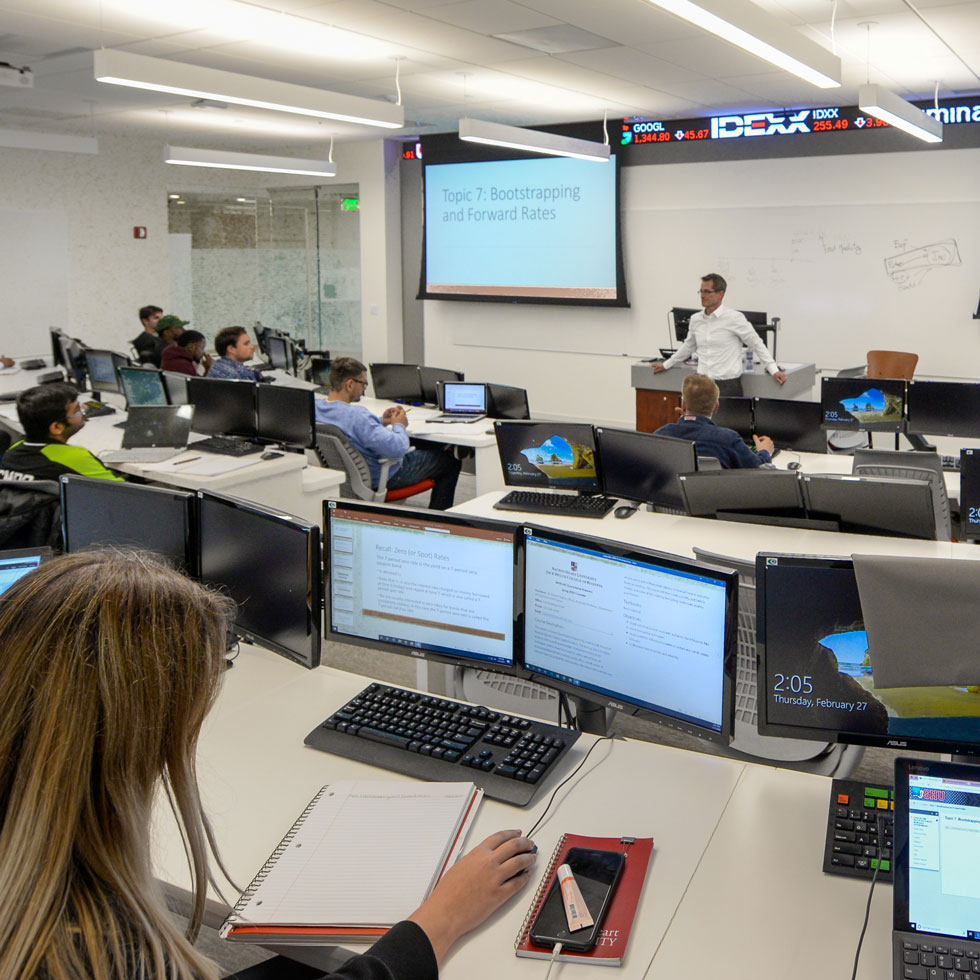 Students listening to teacher in finance lab