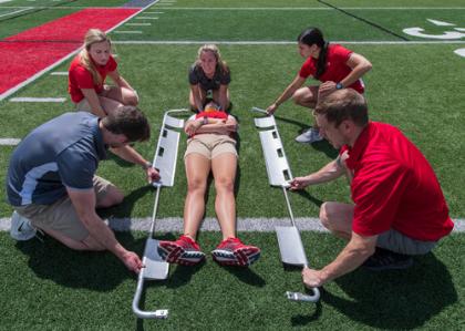 AT students on field practicing with injured athlete