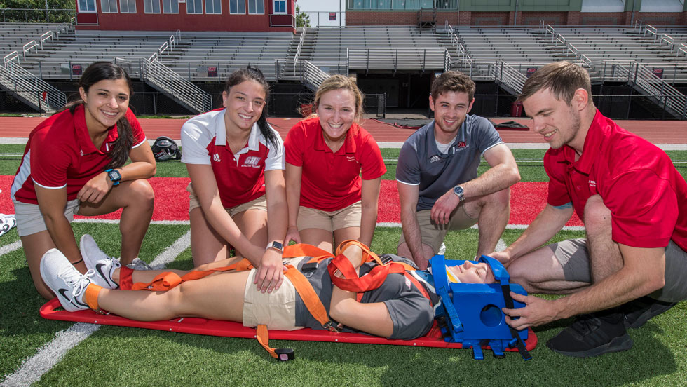 Students practice treating an athlete on the field