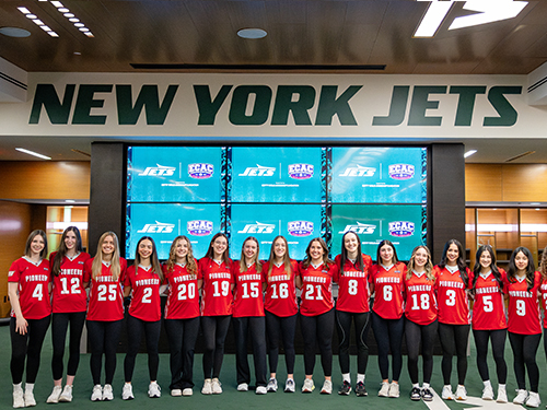 a group of flag football players in front of a New York Jets sign