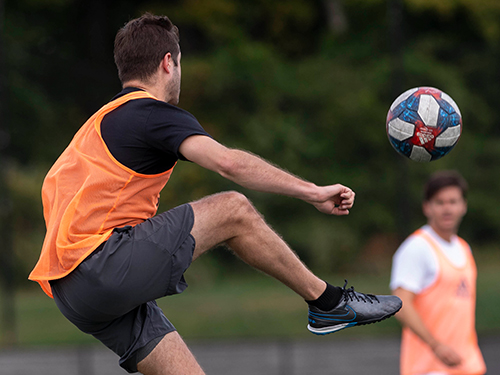 Soccer player kicking a ball in the air