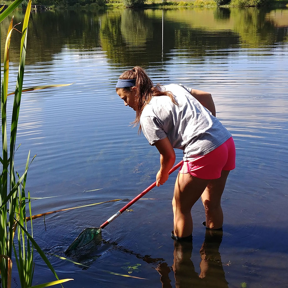 student standing in a pond