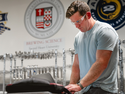 Student using laptop in brew science lab