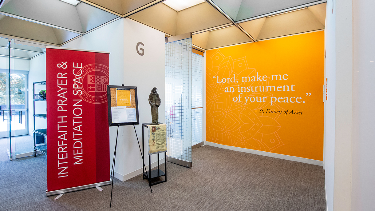 interfaith prayer space banner and statue of francis of assisi