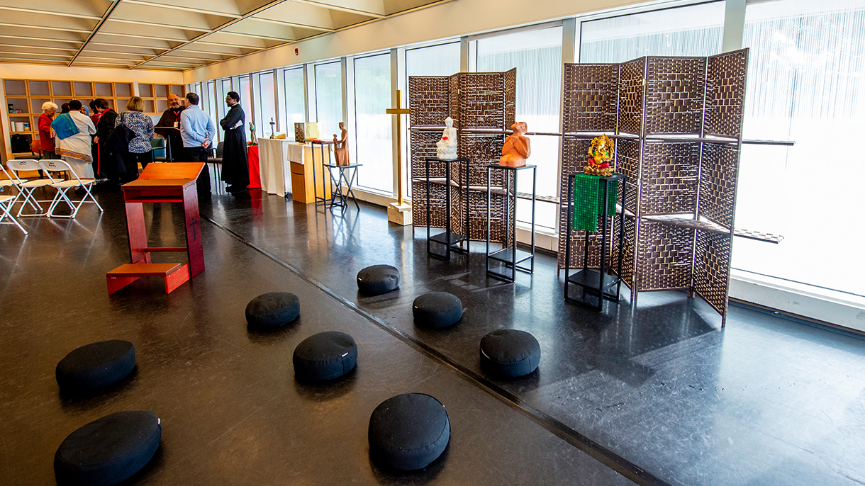 interfaith prayer space with floor cushions and statues