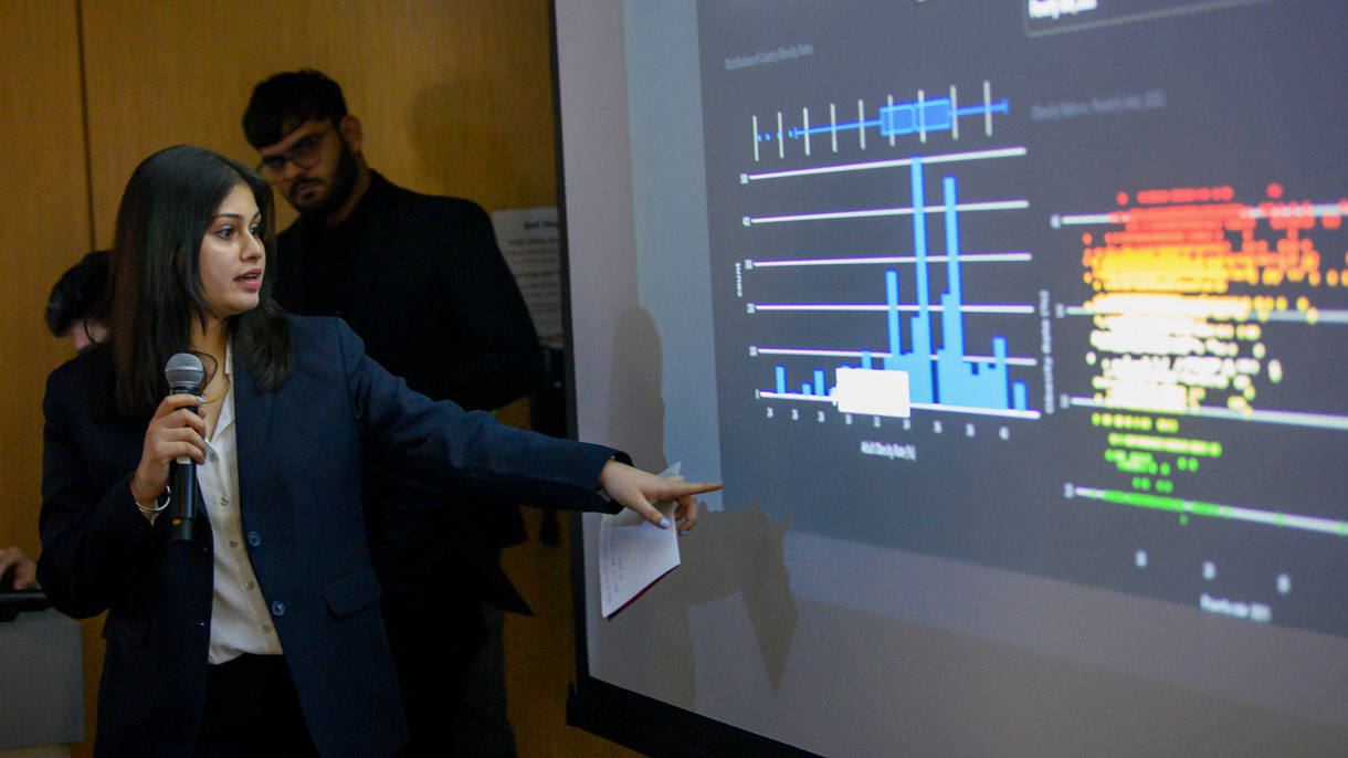 Student talking about a graph on the presentation screen