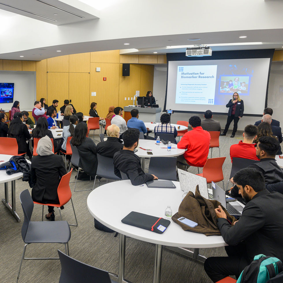 Someone presenting to a room full of people