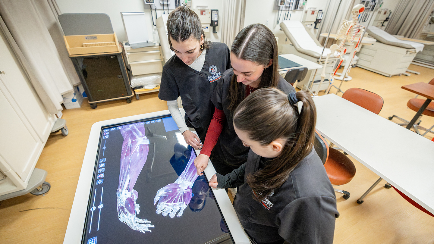 OT students using an anatomage table to study anatomy