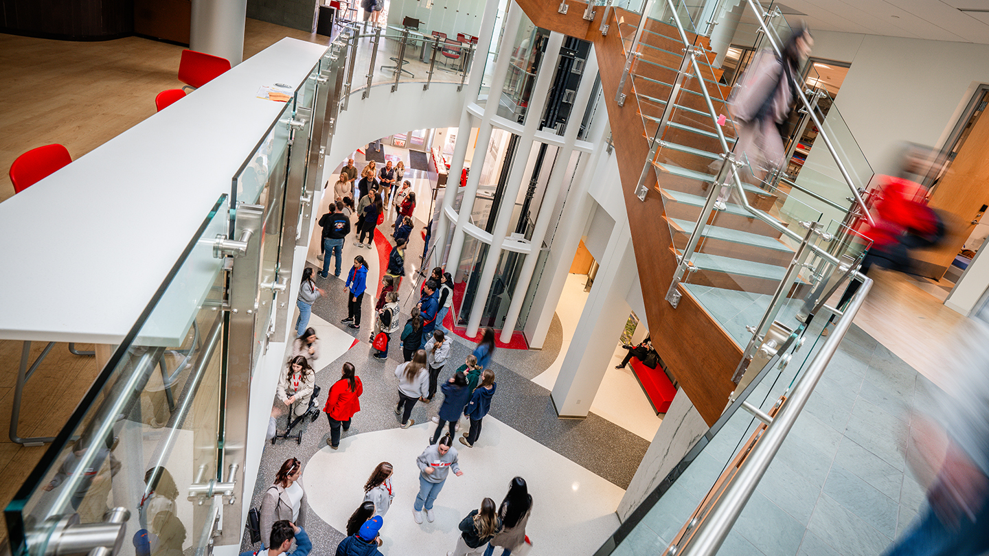 Building atrium showing people walking around and multiple staircases