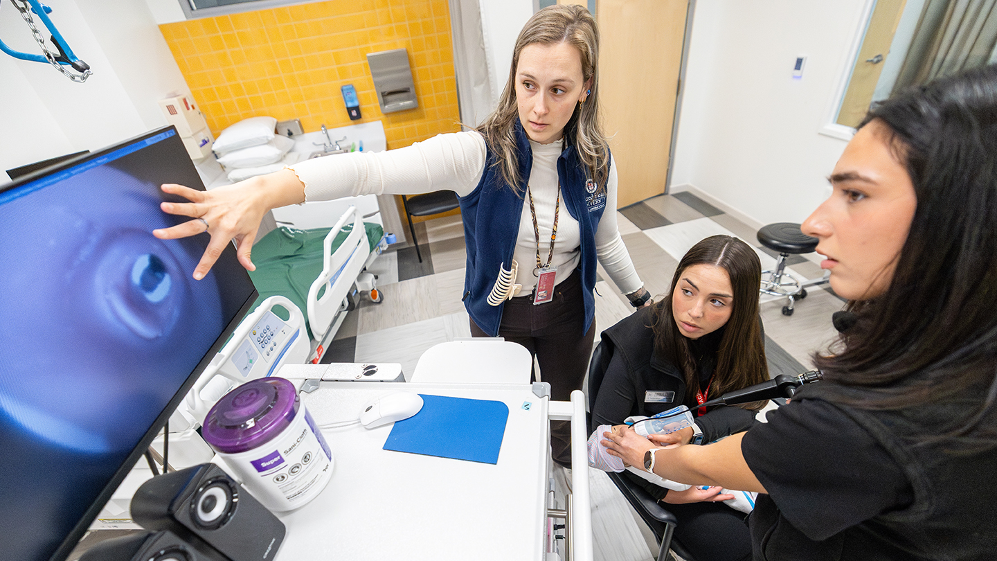 a professor pointing out the view from an esophageal scope on a monitor