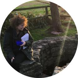 Marie Hulme sitting next to a well