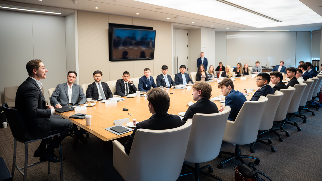 Business students visiting a corporate office and listening to professional at conference table