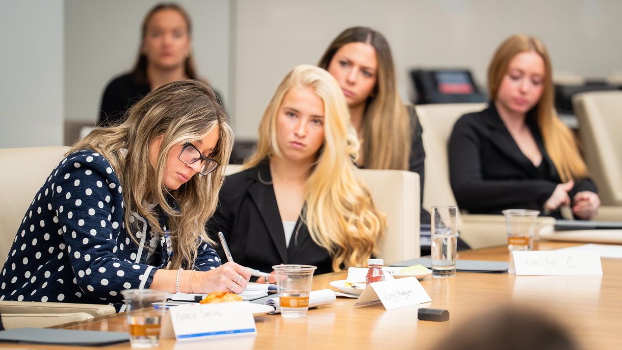 Students listening and taking notes during corporate visit