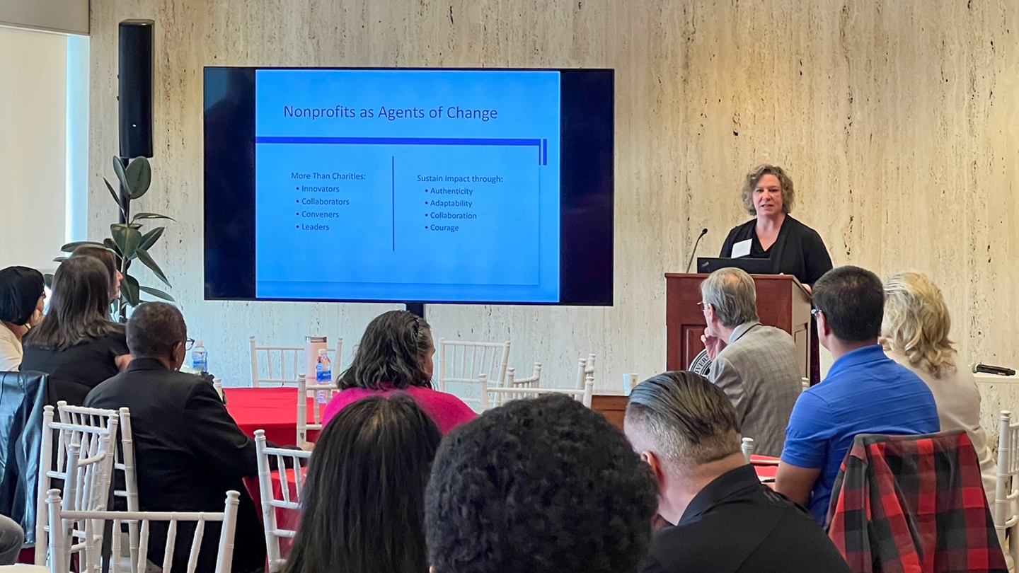 Susan Agamy speaking to a crowd from a podium
