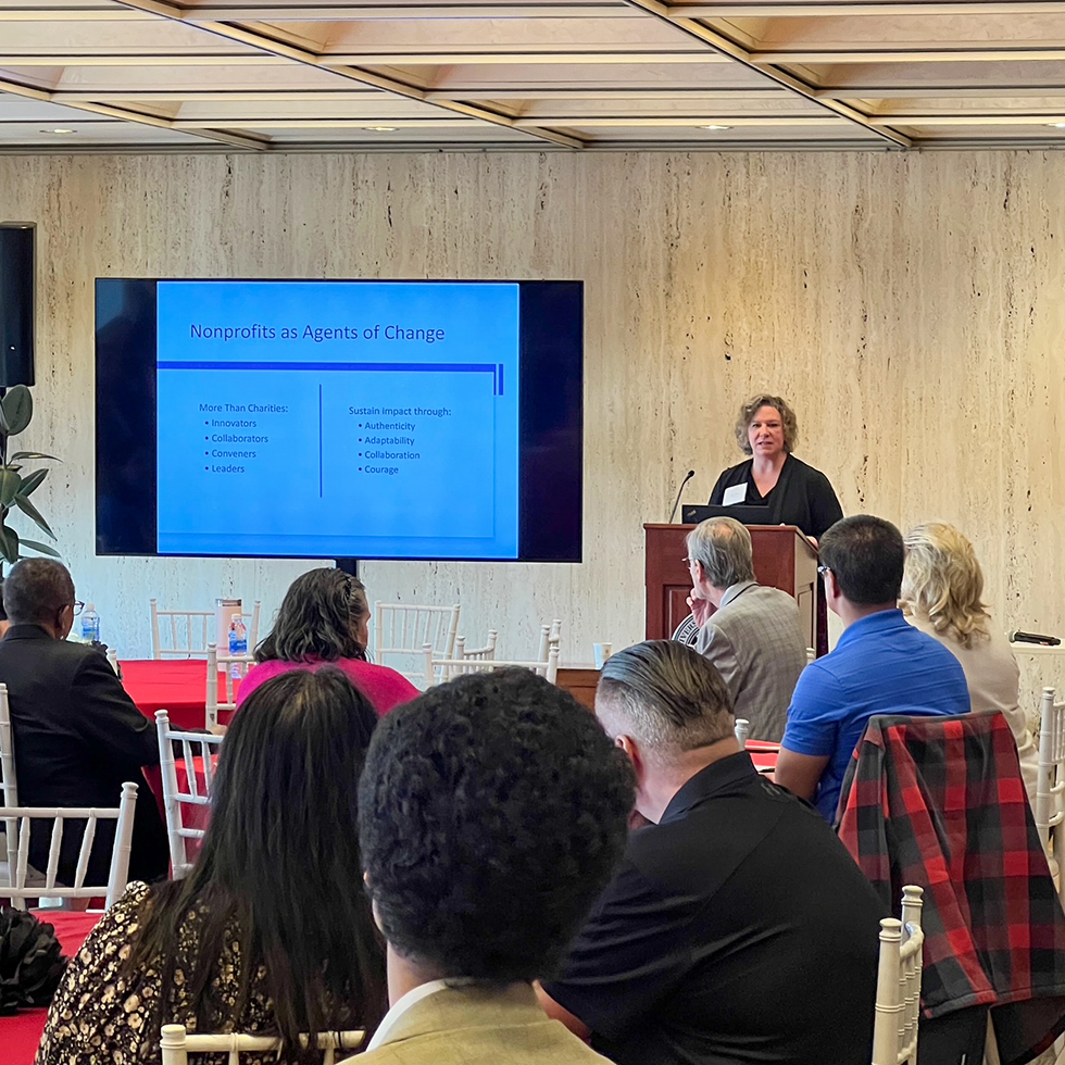 Susan Agamy speaking to a crowd from a podium
