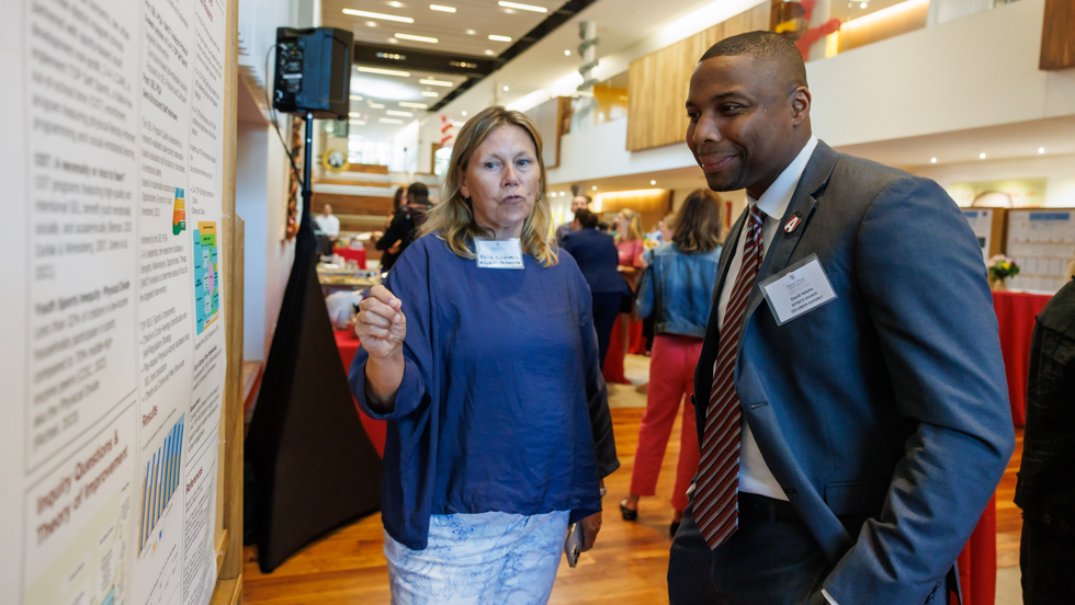 Woman explaining poster to man