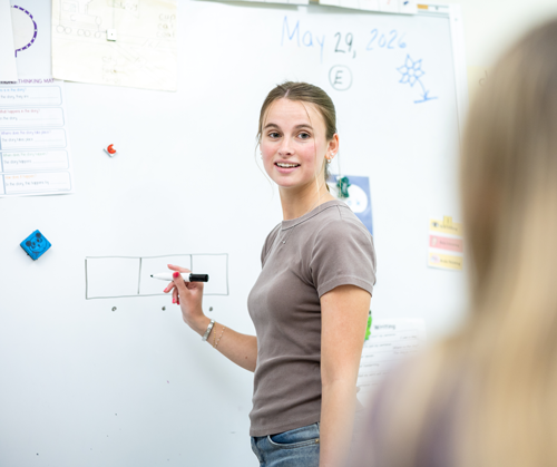 Teacher writing on whiteboard