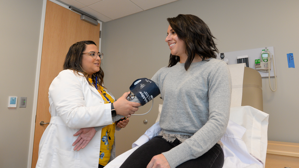 DNP student checking the blood pressure of a patient