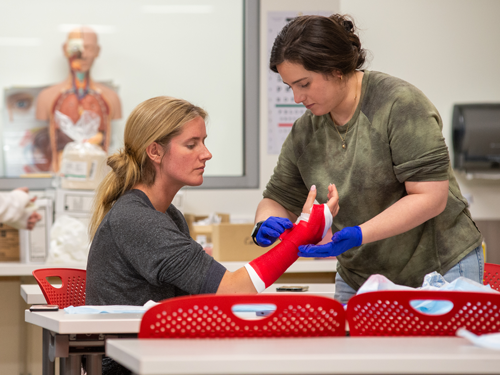 Nursing students practicing putting on an arm cast