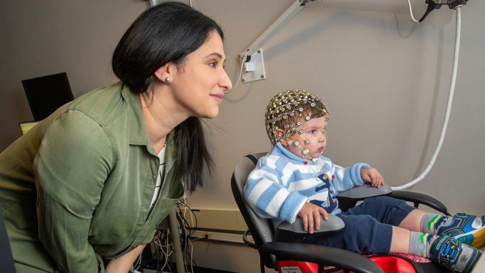 Woman with child with electrodes on head