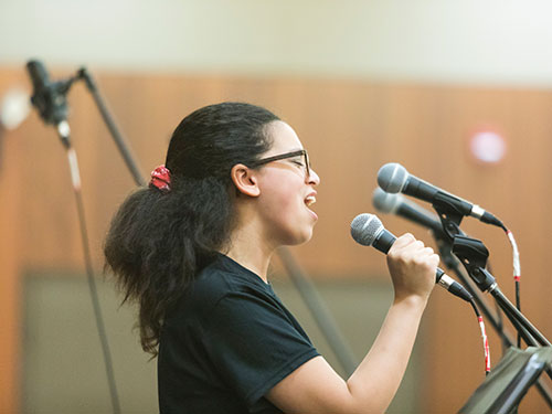 student singing into a microphone