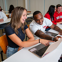 two college students talking in class