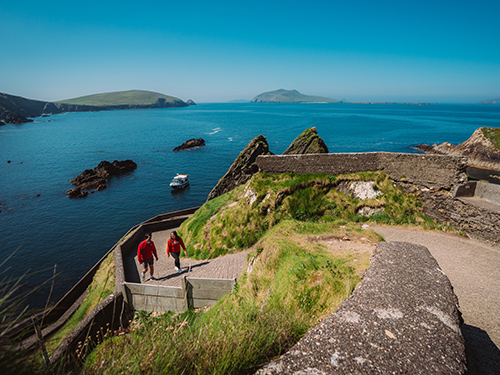 two people walking along a path on the Dingle Ireland coast