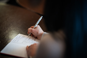 Person writing notes in notebook