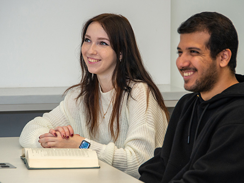 two smiling students in a classroom