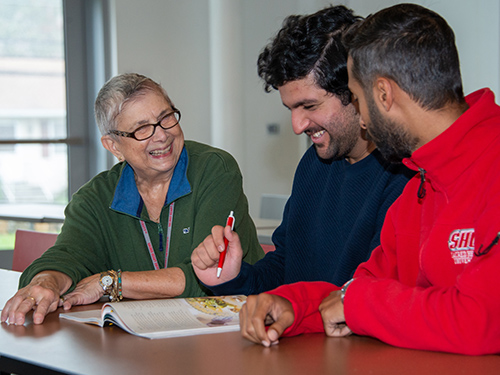 An instructor working with two students in class