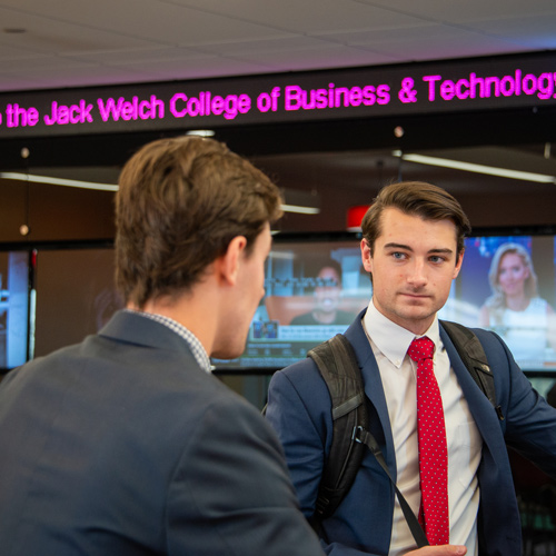 Business students with ticker-tape in the background