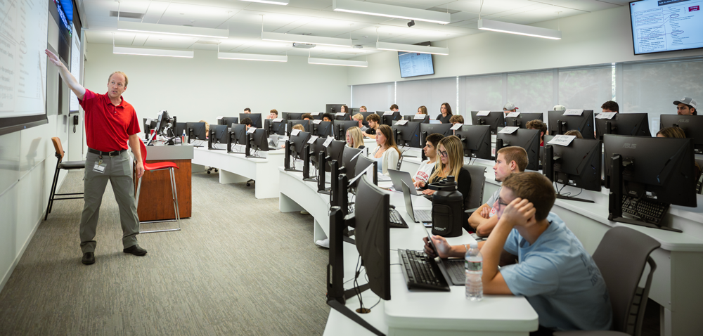 Students listening to professor on computers in Bloomberg Lab