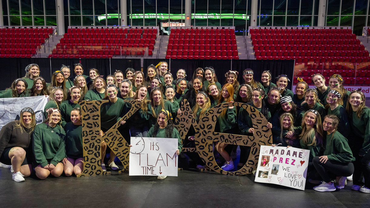 Members of Kappa Alpha Theta holding their Greek letters and two signs for the Greek Sing event