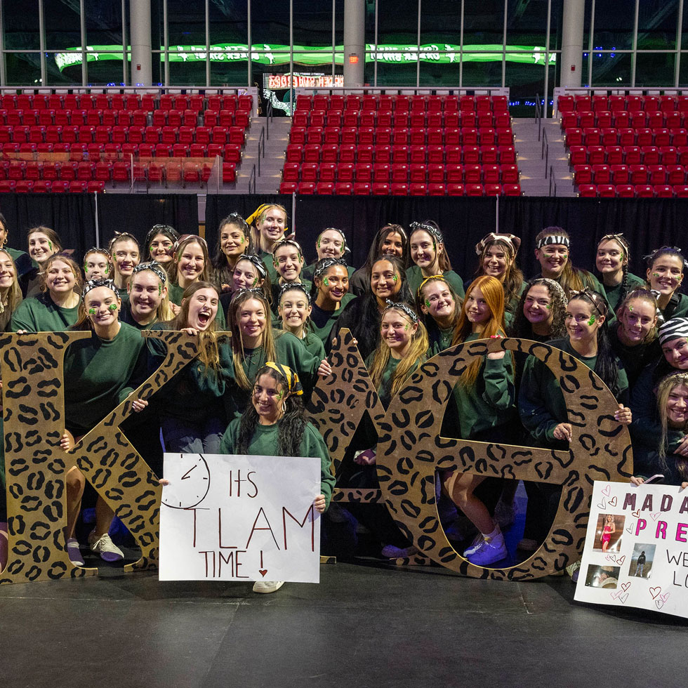 Members of Kappa Alpha Theta holding their Greek letters and two signs for the Greek Sing event