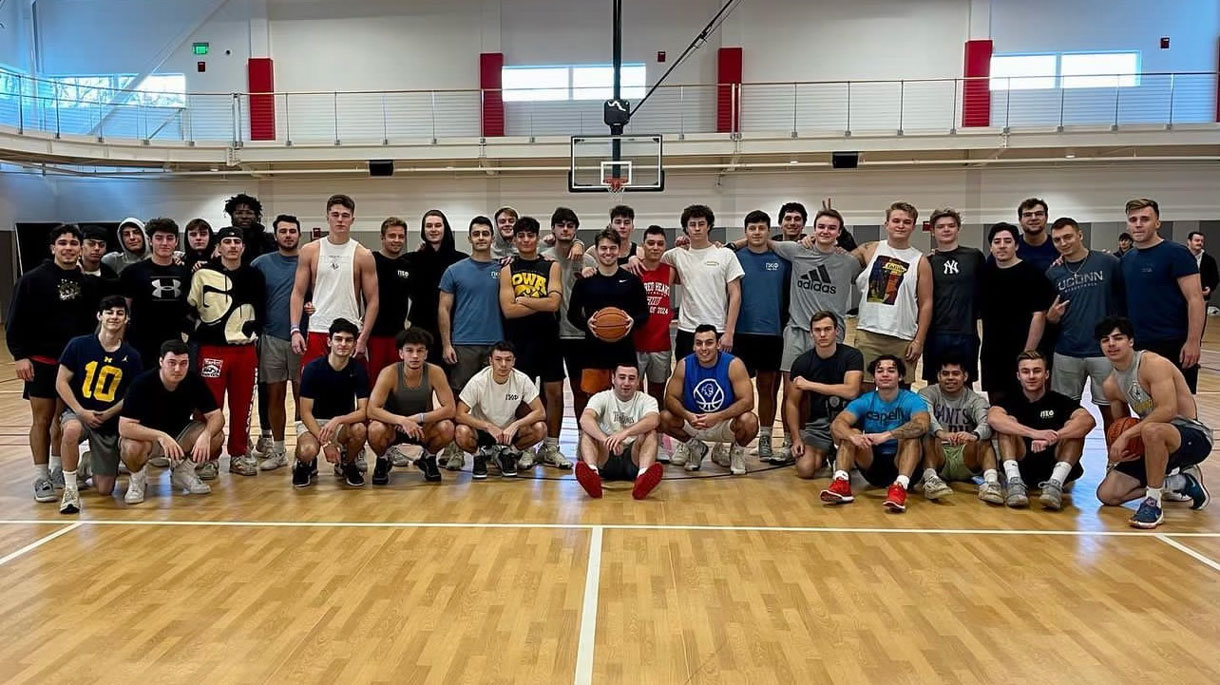 Members of Pi Kappa Phi at a brotherhood event. In athletic wear, playing basketball