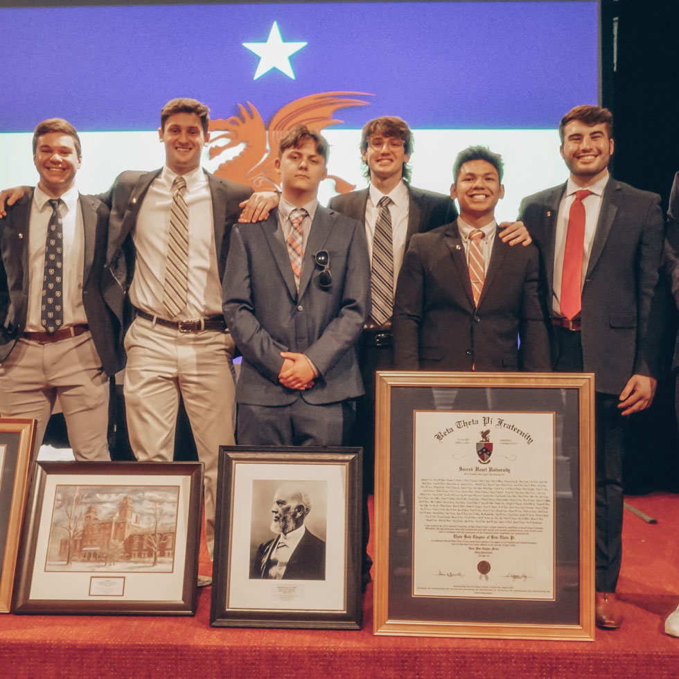 Members of Beta Theta Pi at brotherhood event. All dressed in suit jacket, tie, dress pants