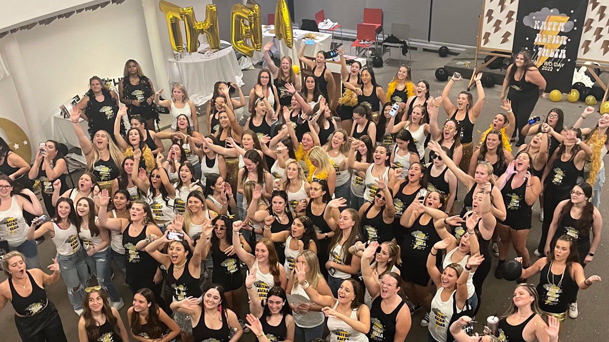 Members of Kappa Alpha Theta cheering during Bid Day. Black and gold theme