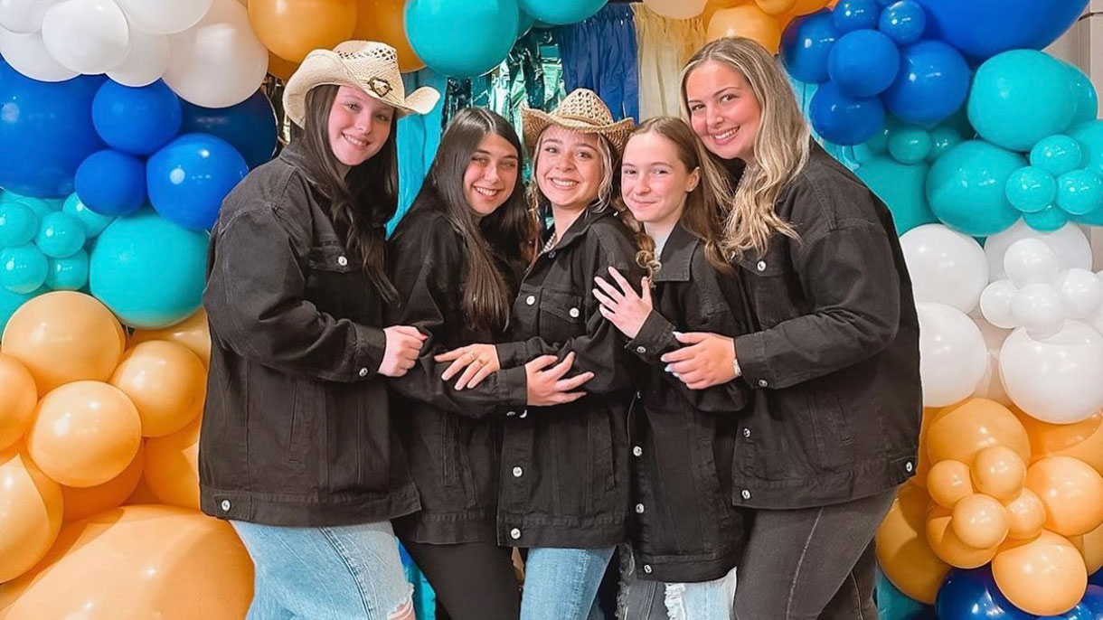 Members of Tri Delta with vibrant colored balloons in the background