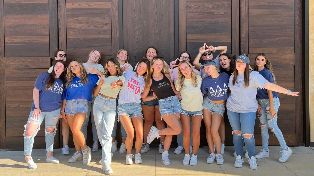 Members of Tri Delta posing for a photo in front of the chapel doors on main campus