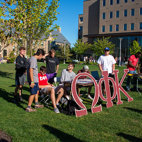 college students manning a fraternity table at an involvement fair