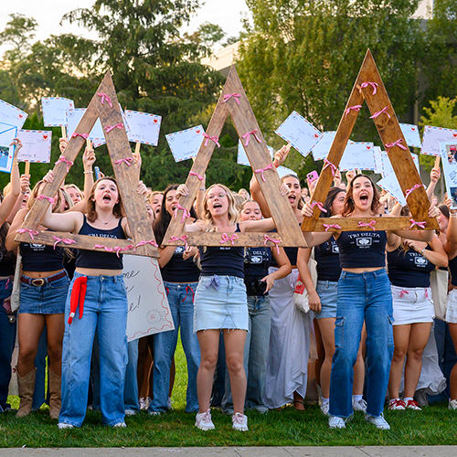 a sorority recruitment event with members holding up their letters