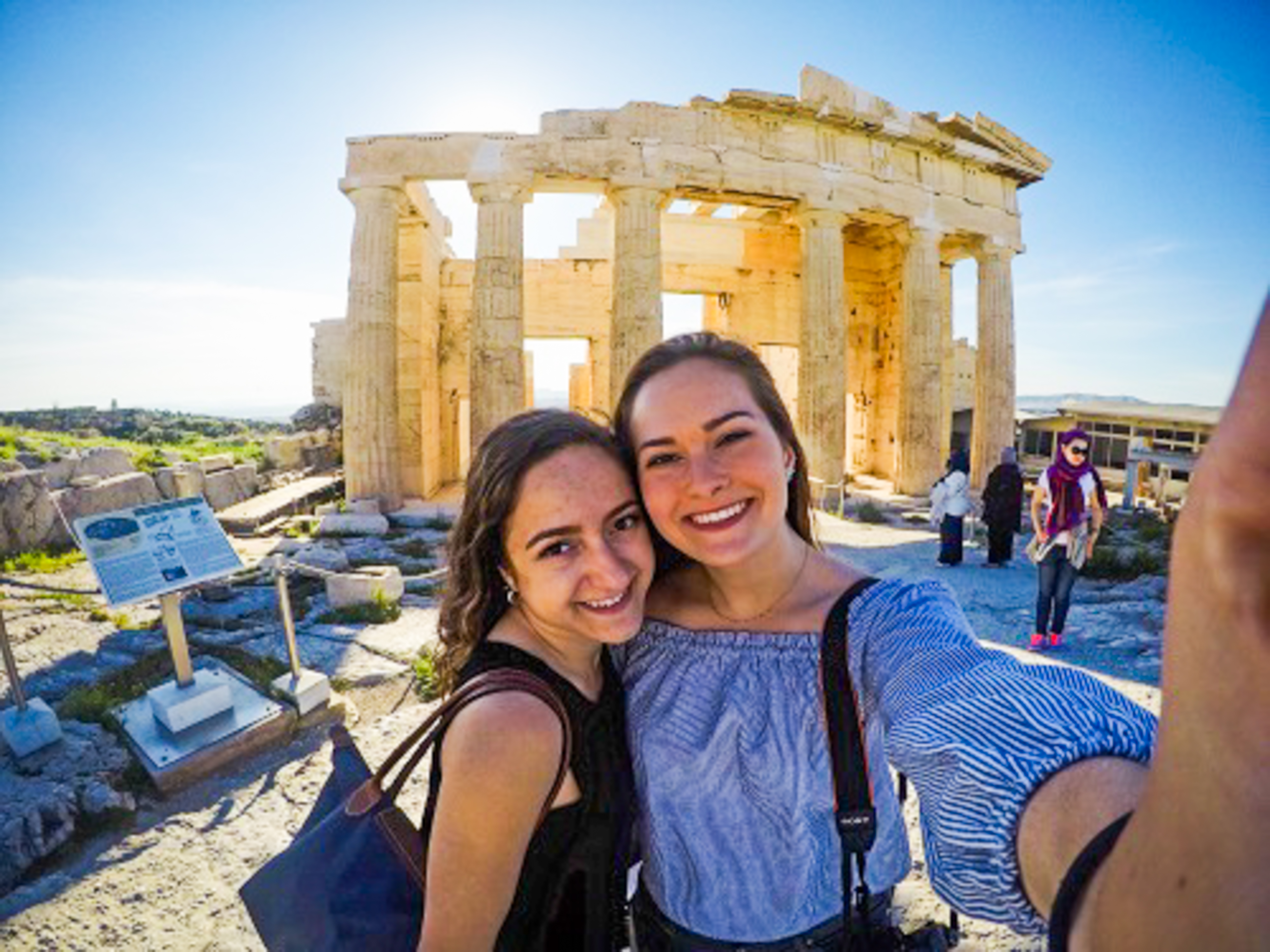 Two girls with ruins in background