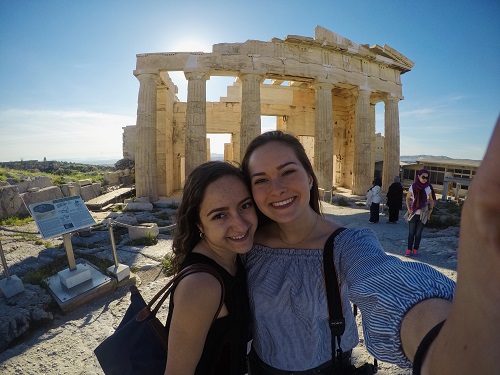 Two girls with ruins in background