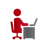 A figure sits on a swivel chair at a desk, while using laptop.
